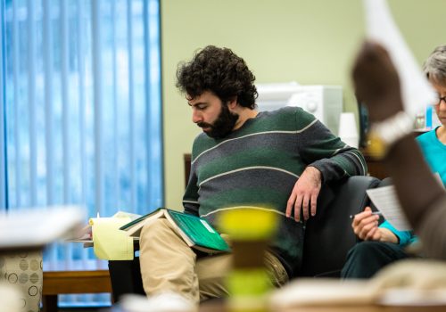 A professor writing notes during an Inquiry ARC reading circle.